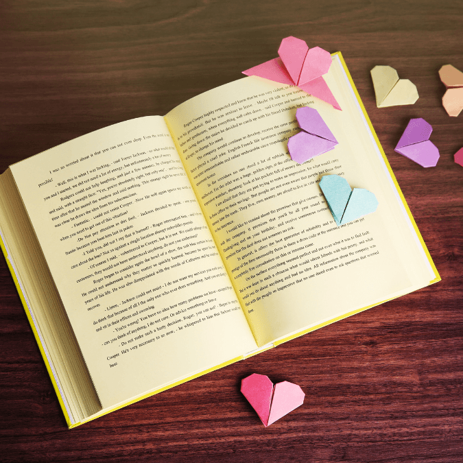 Photo of an open book with paper hearts around it